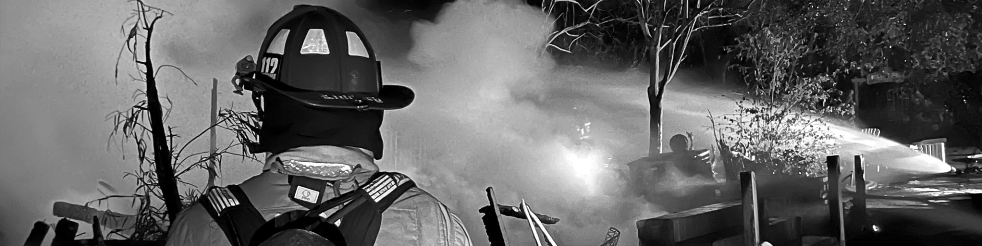 photo of fire fighter facing smoke and back spray