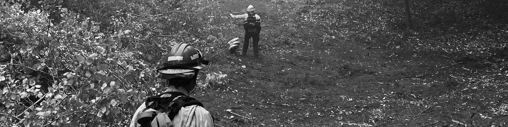 photo of two fire fighters walking on dirt hill